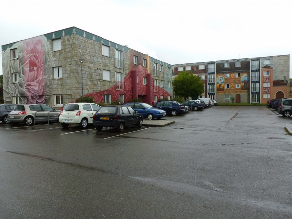 A gauche, le bâtiment avec les fresques sur le thème du parfum et sur la ville de Chartres au fond. 