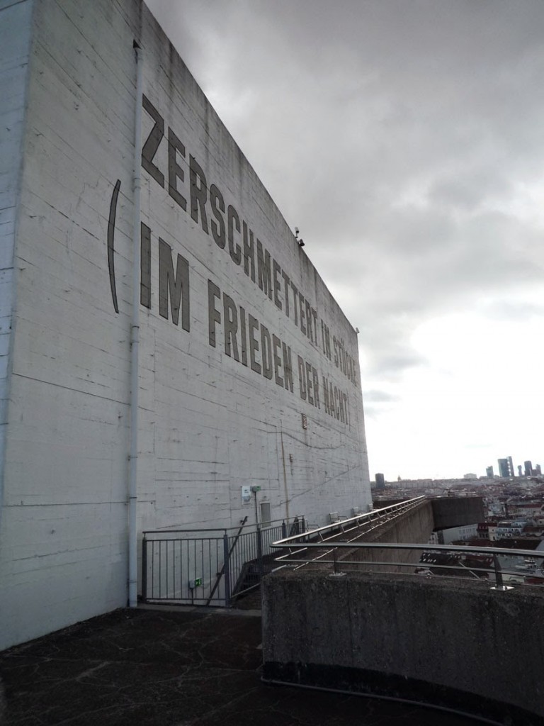 "Zerschmettert in Stücke im Frieden der Nacht" (Brisé en morceaux dans le silence de la nuit) est une œuvre de l'artiste américain Lawrence Weiner (phrase en anglais sur la façade opposée), réalisée en 1991 en tant que mémorial contre la guerre et le fascisme.