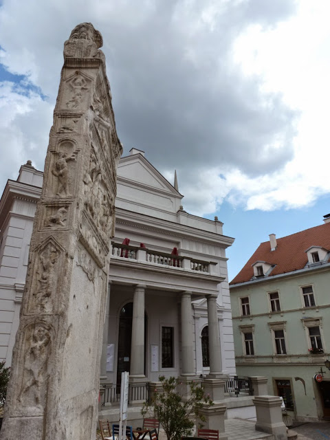 La stèle funéraire du IIe siècle orne la place principale de Ptuj, l'une des villes les plus anciennes de Slovénie. Derrière celle-ci, nous pouvons voir le théâtre municipal. 