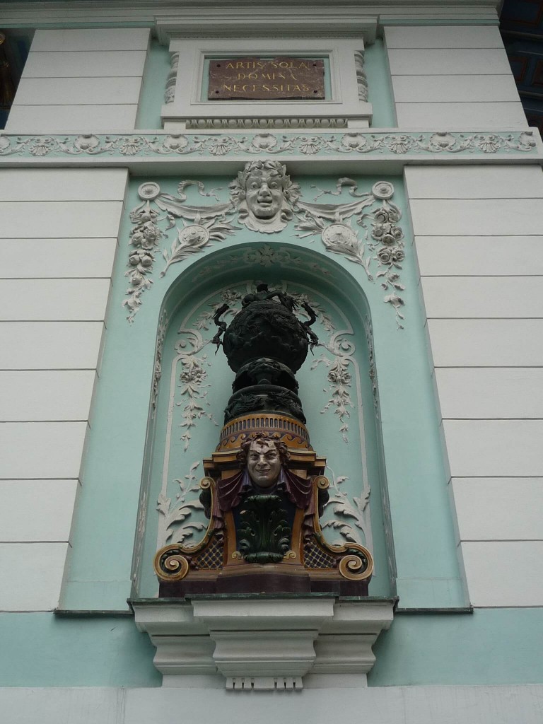 Un des panneaux sur la façade principale, avec l'inscription "Artis sola domina necessitas"